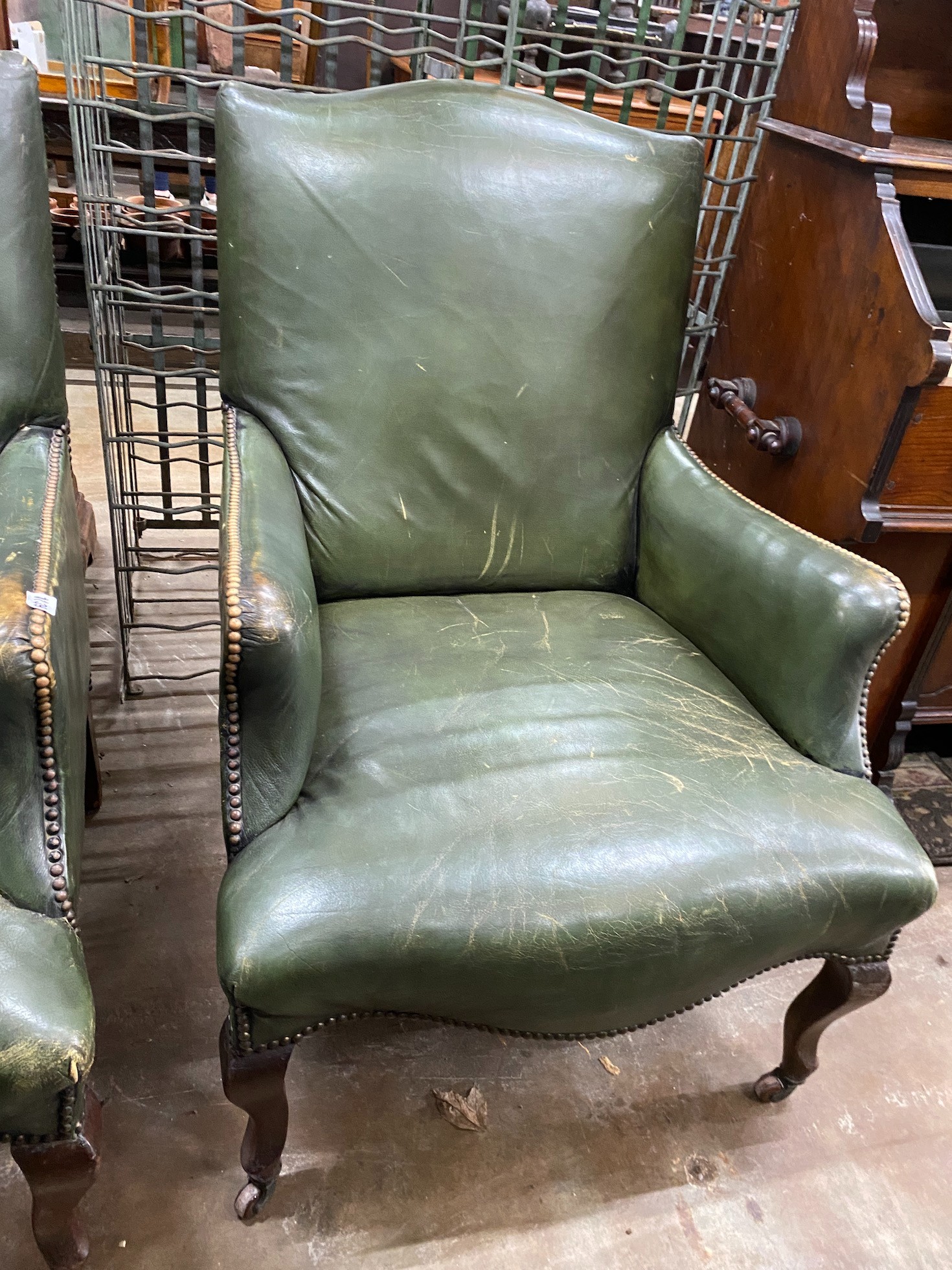A pair of Victorian studded green leather library chairs on cabriole legs, width 69cm, depth 70cm, height 92cm